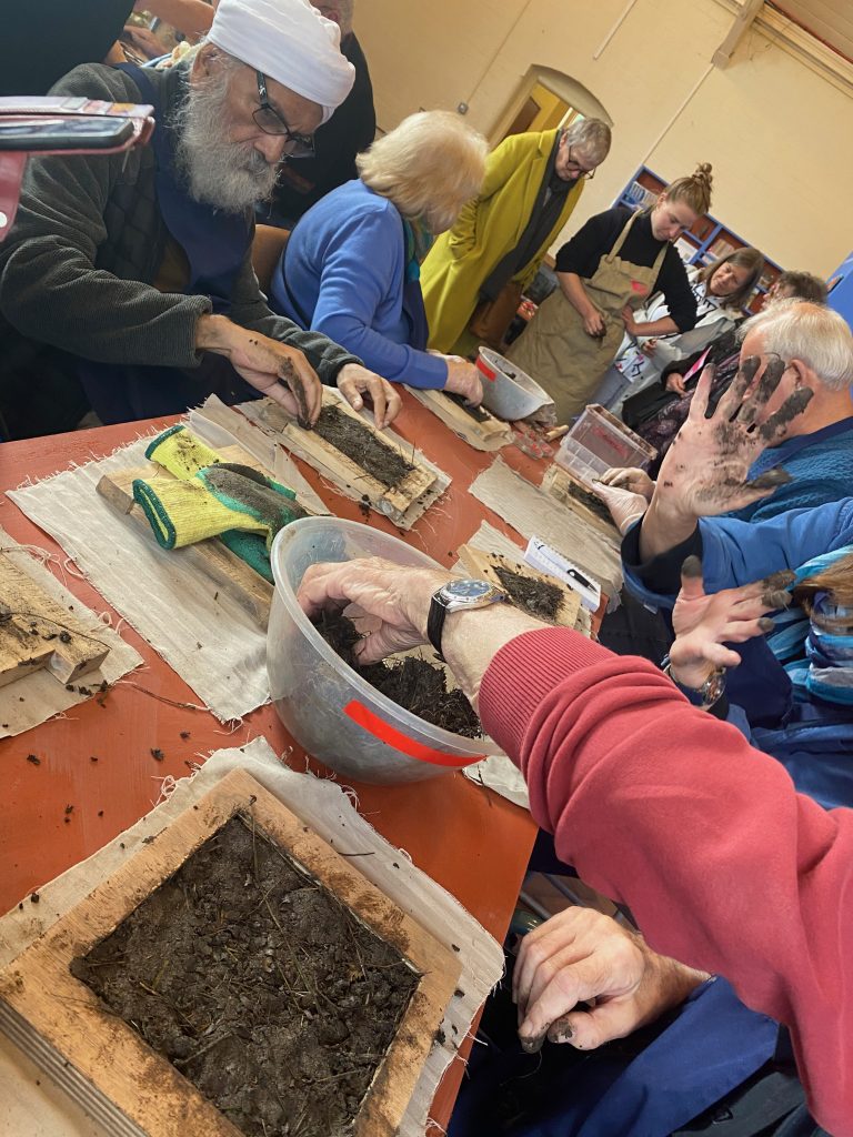 Members of the Dementia and Creativity group make tiles from construction site 'clay'.