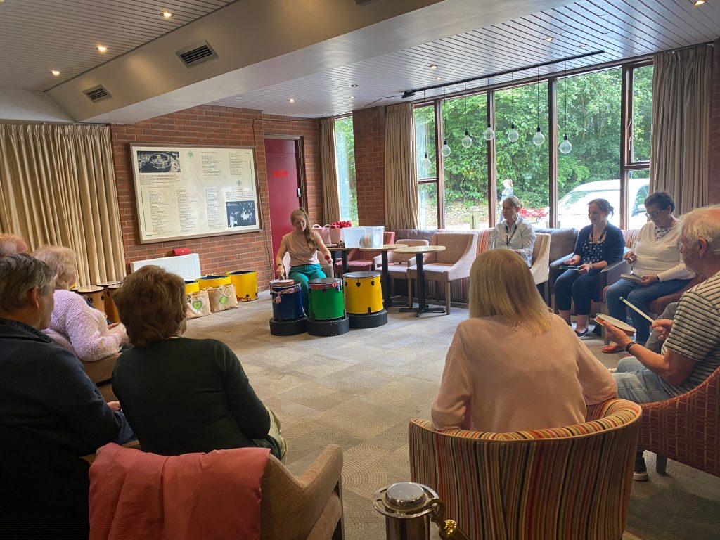 A variety of samba drums are demonstrated to the Dementia and Creativity Group before they have a go themselves.