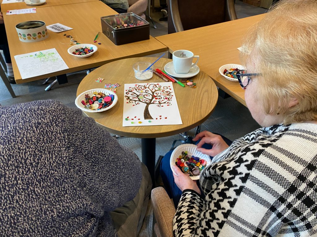 Choosing buttons to embellish a drawing of a tree.