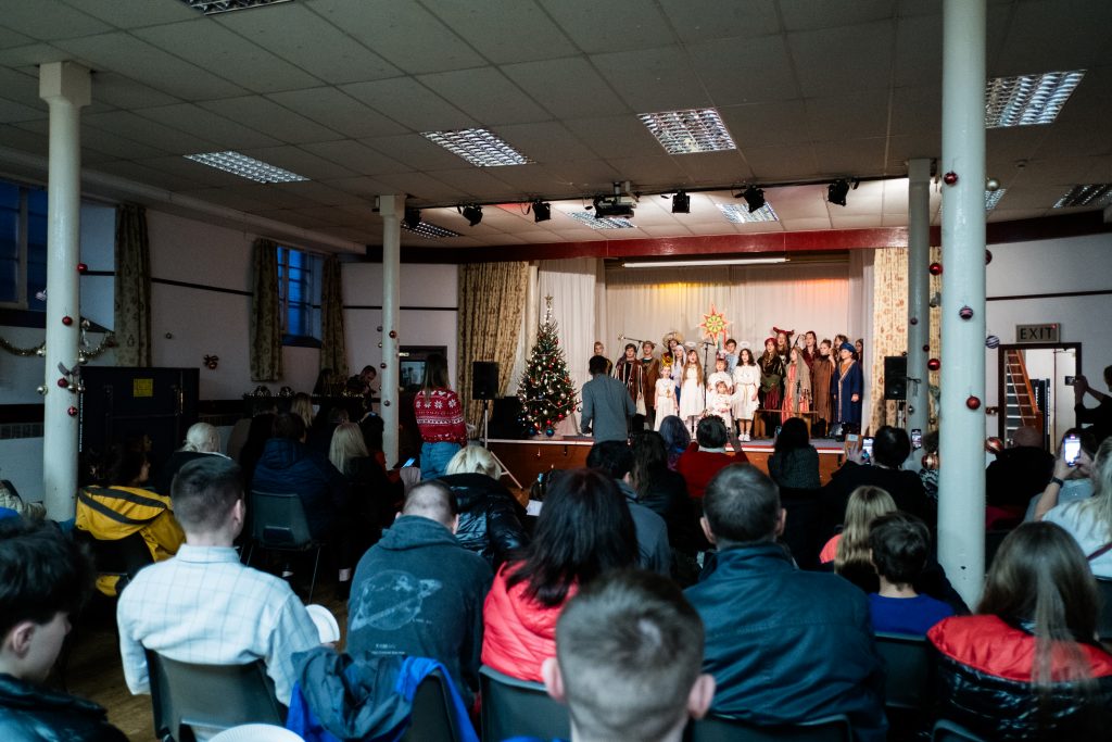 The audience watches the nativity being performed. Picture from the Vertep at Newcastle Congregational Church, performed by Ukrainian families. Credit: Jenny Harper. 