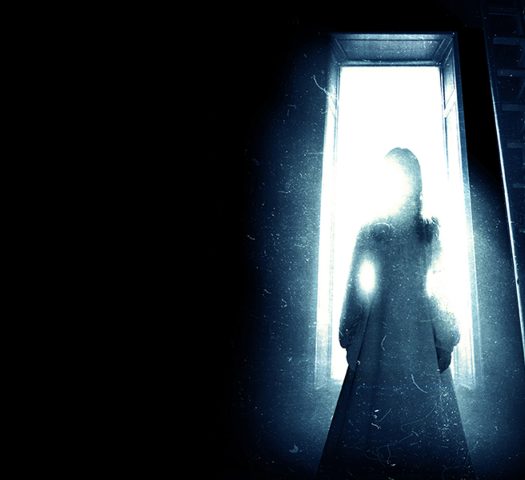 A shadowy figure stands in a doorway in the promotional image for The Haunting play