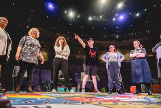 Borderlines' Next Chapter group stand on a giant snakes and ladders board. One of the participants points at something in the distance. Credit Andrew Billington
