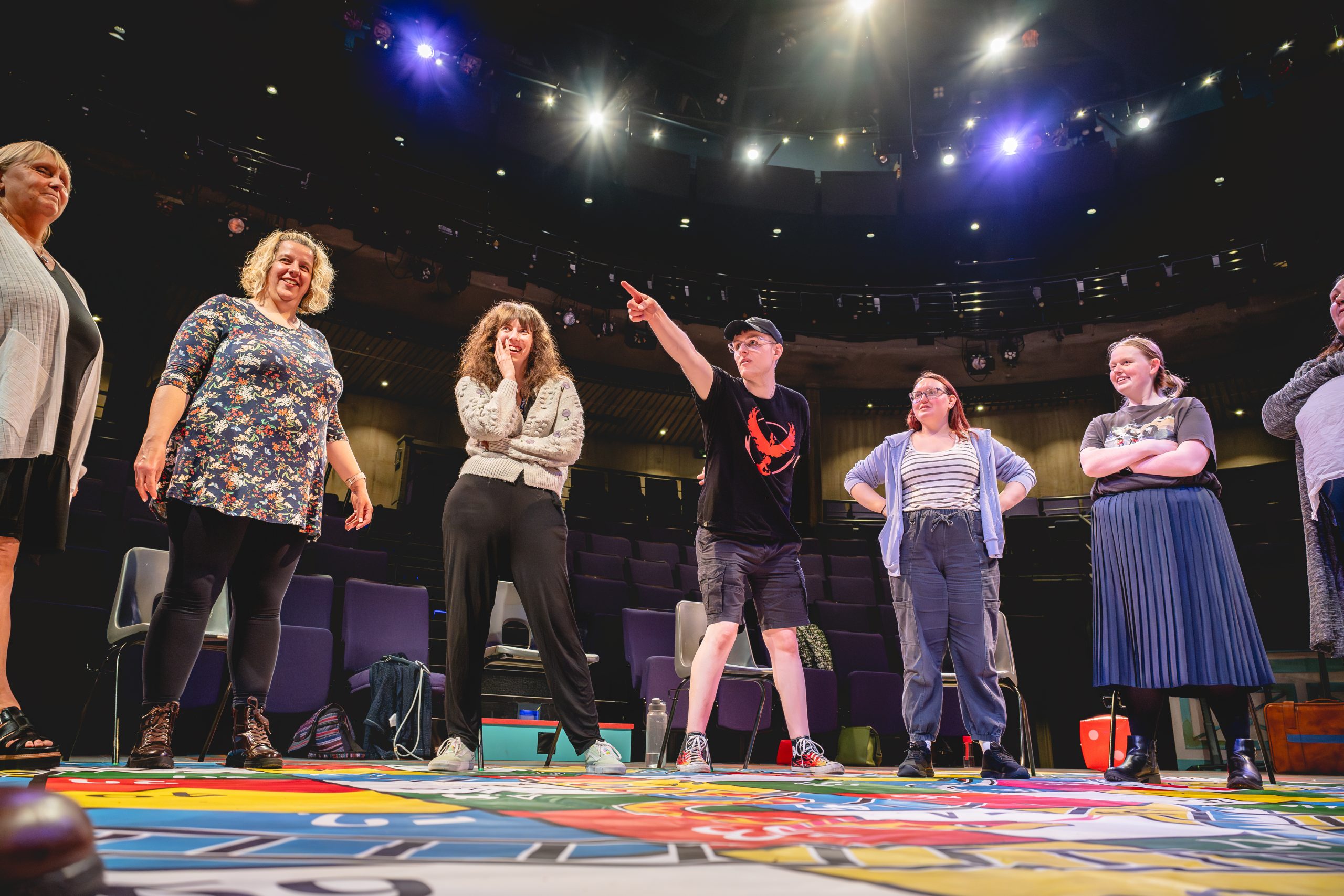 Borderlines' Next Chapter group stand on a giant snakes and ladders board. One of the participants points at something in the distance. Credit Andrew Billington